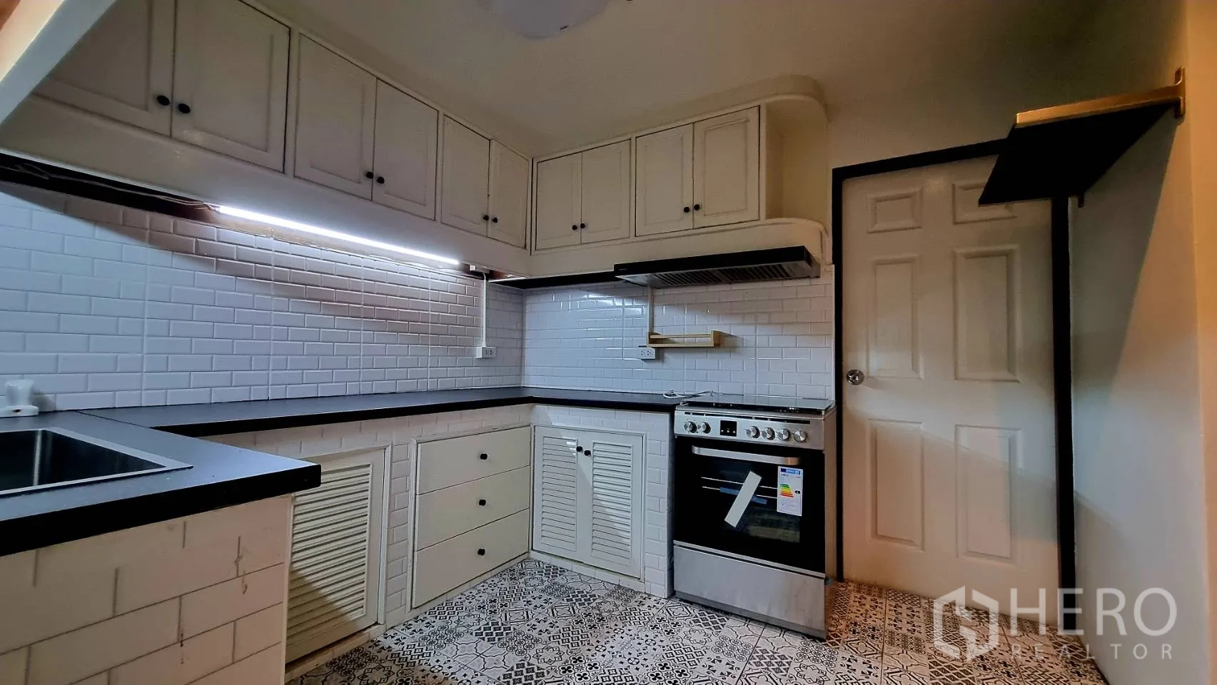 Condominium for rent in Watthana, Bangkok - Cooking zone featuring built-in oven, range hood and ample counter space.