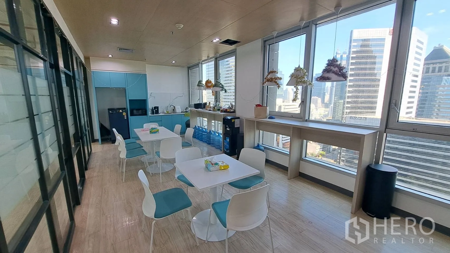 办公空间 出租在Yan Nawa, Bangkok - 员工茶水间，蓝色橱柜、咖啡座与城市景色