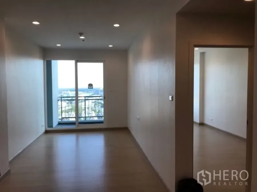 公寓 出售在Yan Nawa, Bangkok - 明亮客厅，木地板与筒灯，落地阳台门通向城市景观