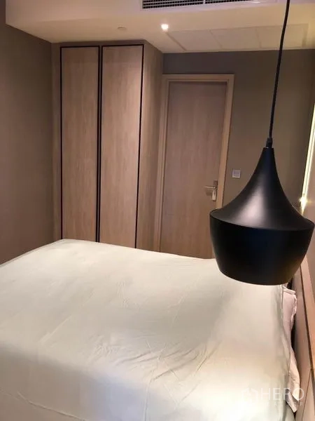 Condominium for rent in Din Daeng, Bangkok - Cozy bedroom with pendant bedside light, built-in wardrobe, and wooden door.