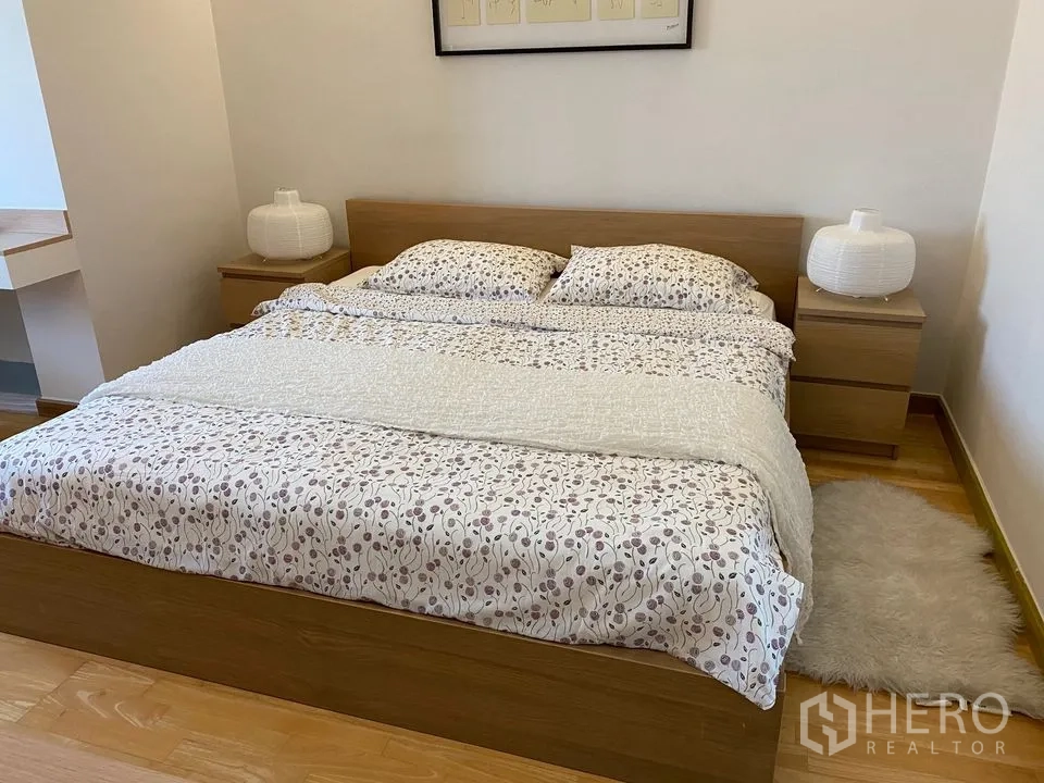 Condominium for rent or sale in Phra Khanong, Bangkok - Cozy bedroom with double bed, matching bedside tables and warm wood flooring.
