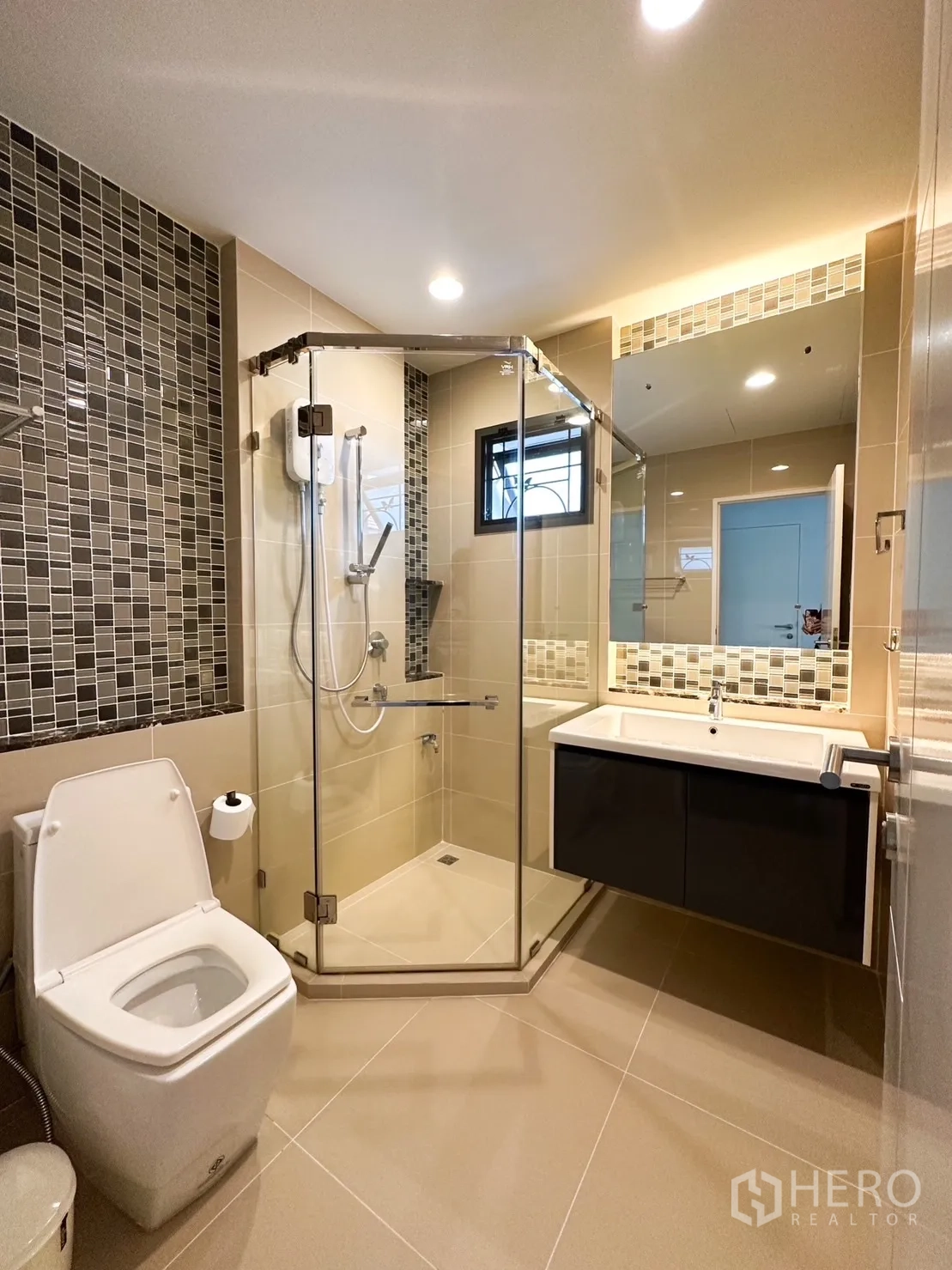 Detached House for rent or sale in Bang Kapi, Bangkok - Bathroom with corner glass shower, mosaic feature wall and vanity.