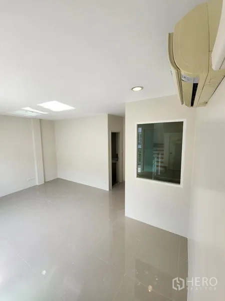 联排别墅 出租在Wang Thonglang, Bangkok - 开阔房间，亮面地砖，设内窗与通往卫生间的门。
