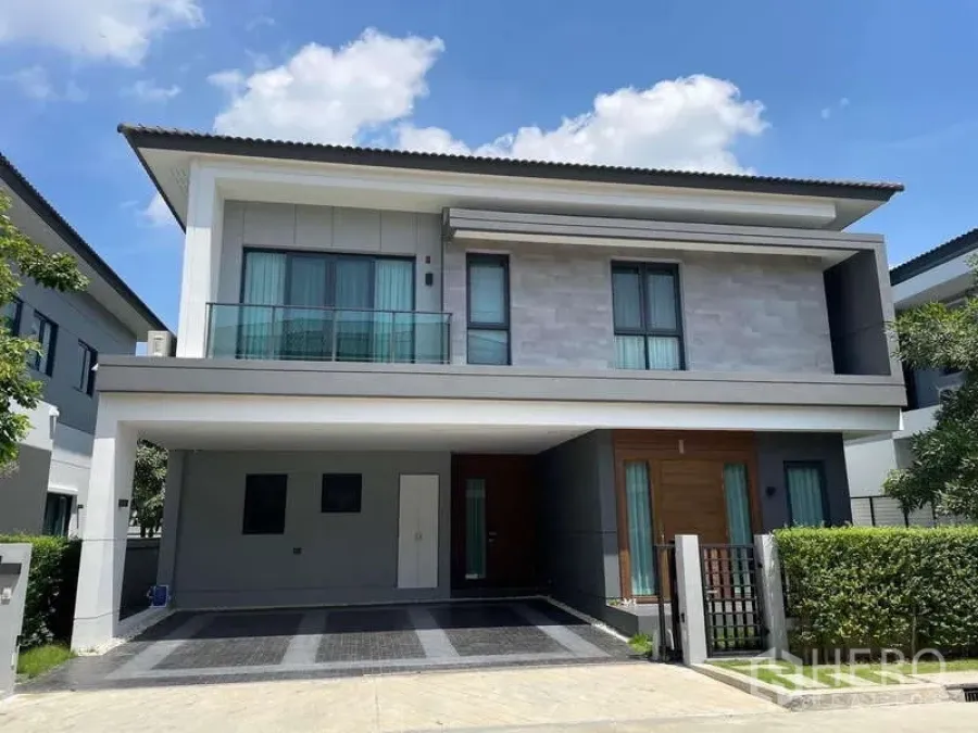 Detached House for rent in Bang Phli, Samut Prakan - Front elevation of the detached house with driveway, gate and trimmed hedges.