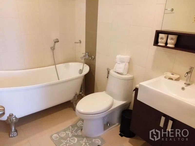 公寓 出租或出售在Pathum Wan, Bangkok - 浴室设独立爪足浴缸、坐便和洗手台镜柜。