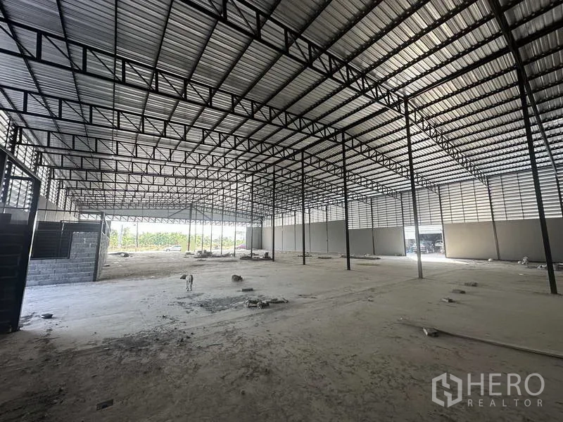 Warehouse for rent in Lam Luk Ka, Pathum Thani - Broad interior shot highlighting multiple bays and a wide-span steel frame roof.