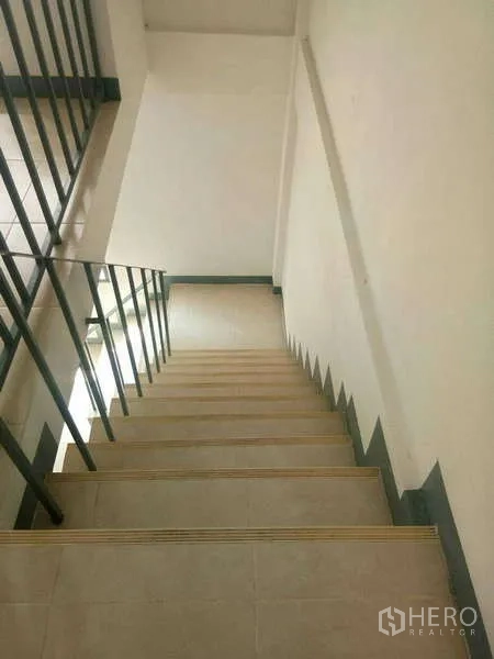 Shophouse for rent in Bang Na, Bangkok - Internal staircase with metal handrail and non-slip steps inside the shophouse.