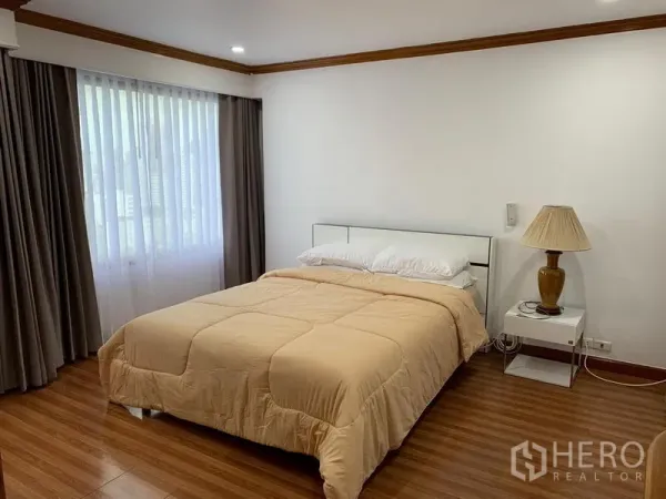 公寓 出租在Watthana, Bangkok - 卧室配木地板、窗帘与床头灯，位于素坤逸23的 Liberty Park 1。