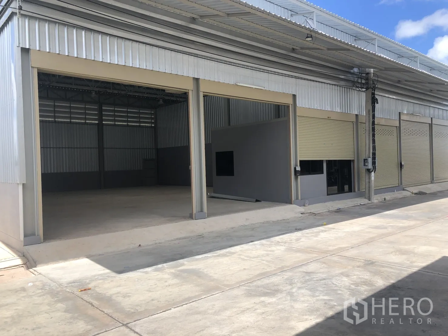 Warehouse for rent in Phra Samut Chedi, Samut Prakan - Open bay warehouse with tall entry, adjacent office box, and smooth loading apron.