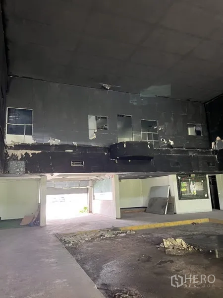 Warehouse for rent in Bang Kapi, Bangkok - Black-clad mezzanine wall above open loading area inside the warehouse, needs renovation.