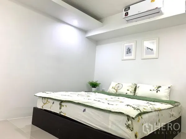 Condominium for rent or sale in Khlong Toei, Bangkok - Cozy bedroom view with recessed lighting, botanical wall art and a neatly made double bed.
