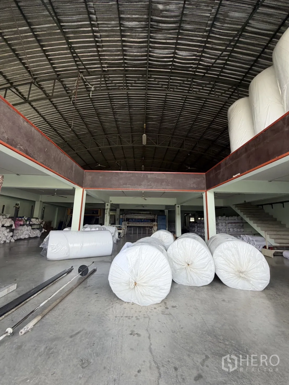 工厂 for rent or sale in Bang Bon, Bangkok - 高挑装卸与生产大厅，摆放大型卷材与楼梯。