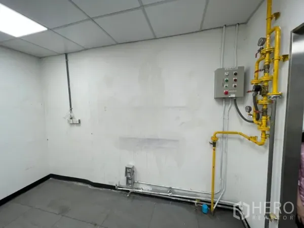 零售空间 出租在Watthana, Bangkok - 室内公用设施墙，带黄色燃气管道、控制面板与管线。