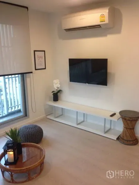 คอนโด ให้เช่าในSathon, Bangkok - ผนังทีวีพร้อมชั้นวางแบบลอย เครื่องปรับอากาศ และหน้าต่างในโซนนั่งเล่นของคอนโด.