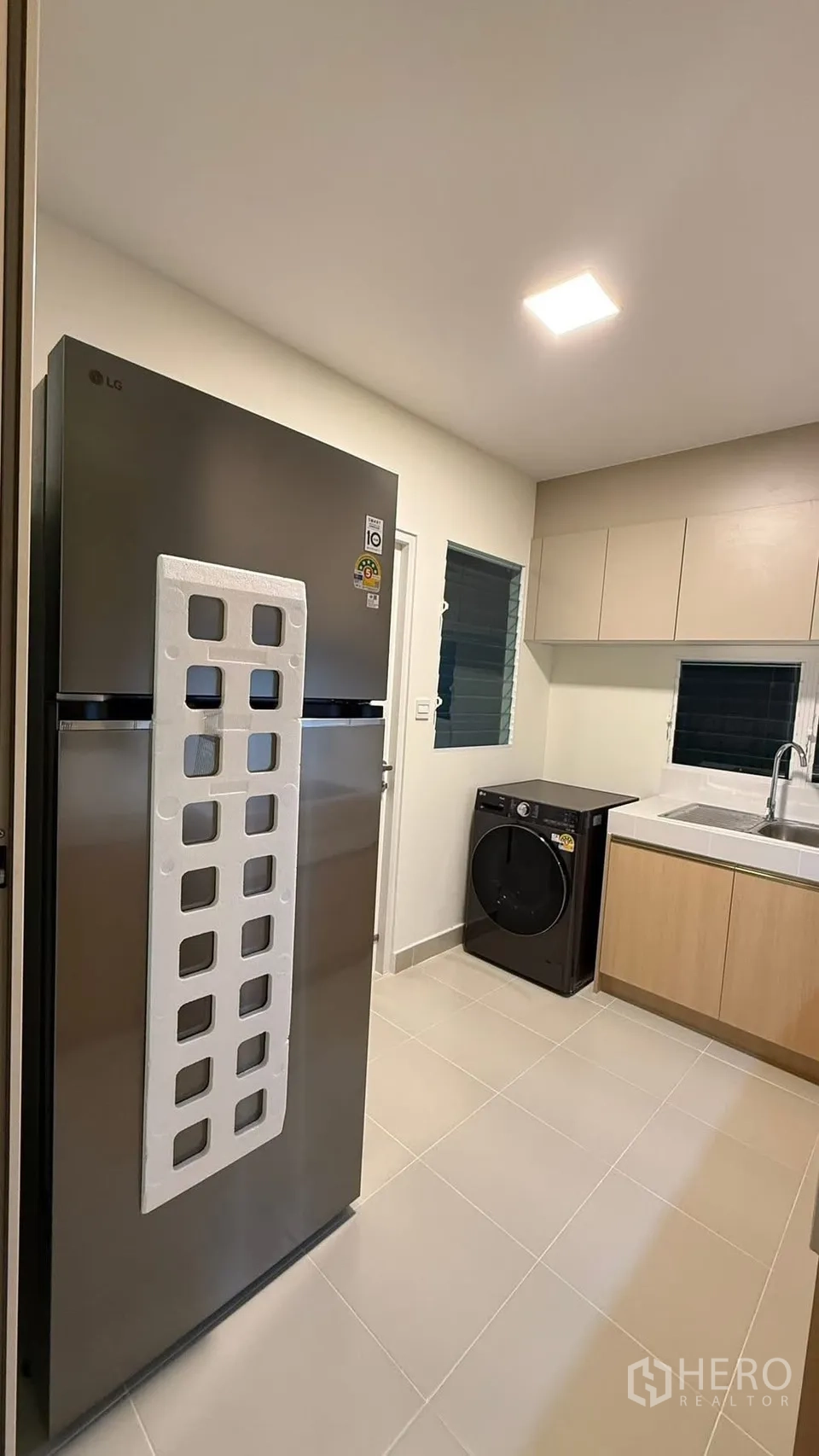 Detached House for rent in Bang Phli, Samut Prakan - Compact kitchen with new two-door fridge, washer, and beige built-in cabinets.