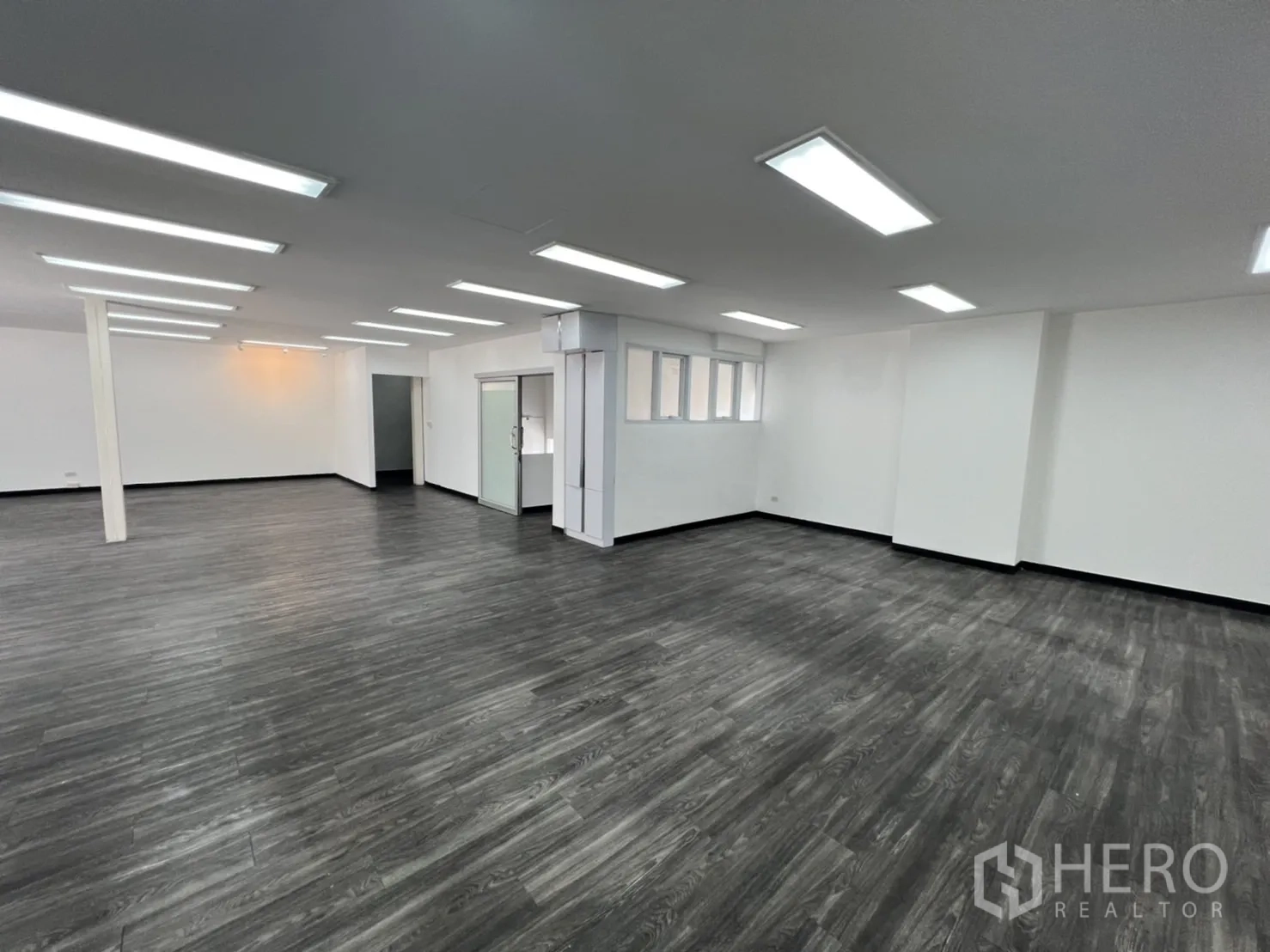 Retail Space for rent in Sathon, Bangkok - Spacious open-plan area with a glass partition and dark wood floors.