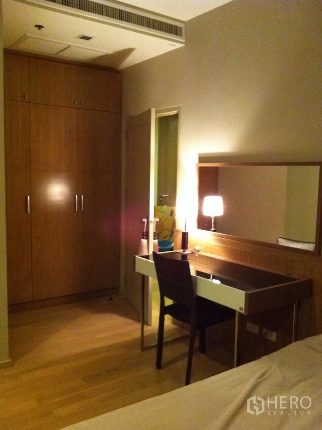 Condominium for rent or sale in Watthana, Bangkok - Bedroom corner featuring a built-in wardrobe and a wood dressing desk with mirror.