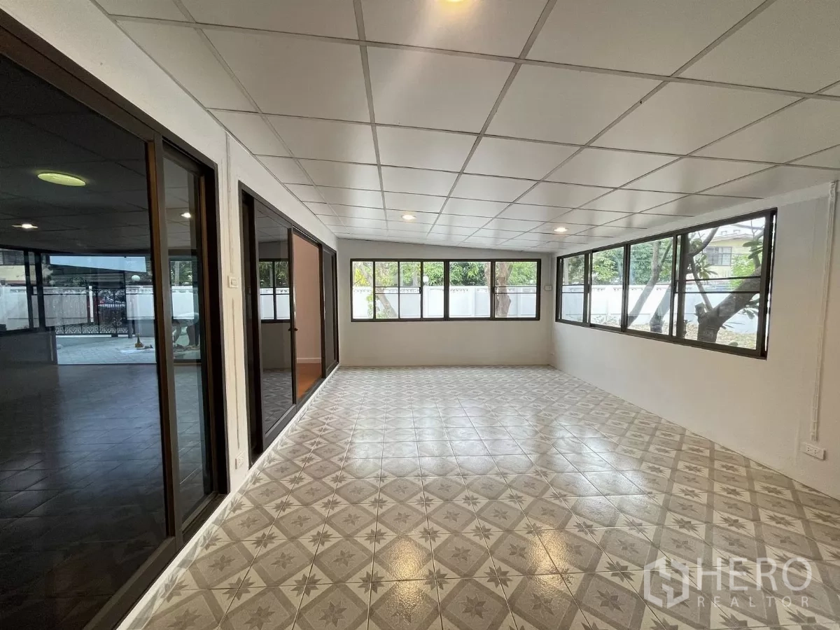 Home Office for rent in Din Daeng, Bangkok - Enclosed sunroom with patterned tiles and wraparound windows overlooking the yard.