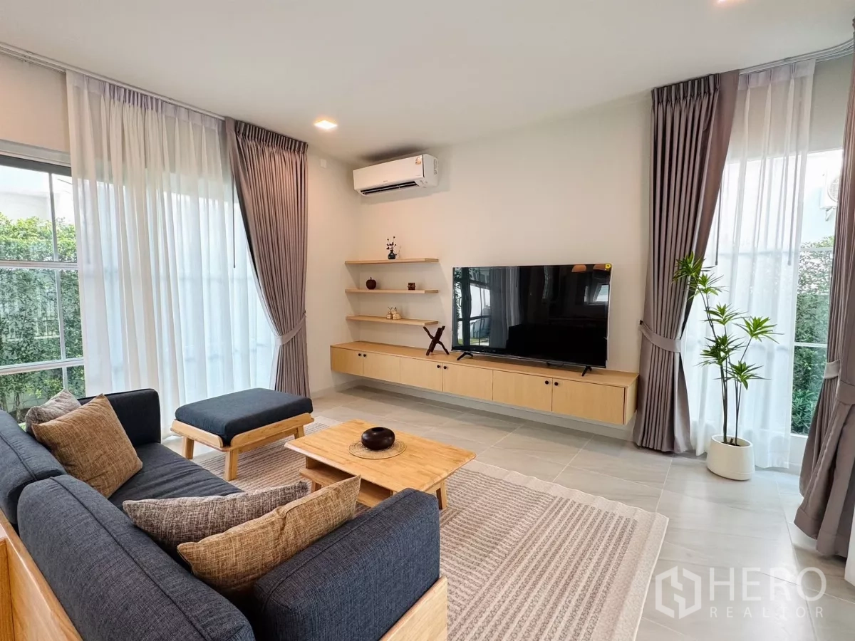 独立式住宅 出租在Bang Phli, Samut Prakan - 舒适客厅，沙发、悬浮电视柜与转角窗