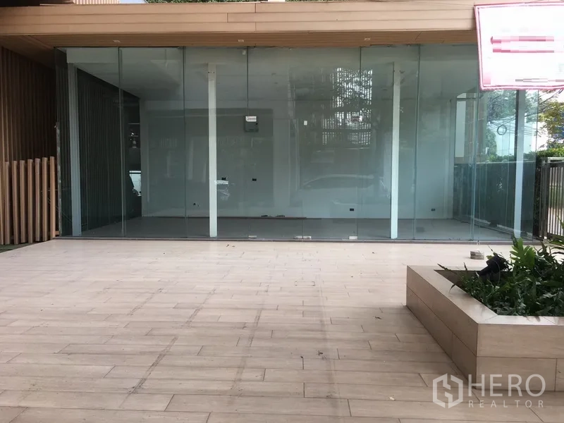 零售空间 出租在Watthana, Bangkok - 空置的玻璃临街铺面，开间布局与宽敞门前平台、花坛。