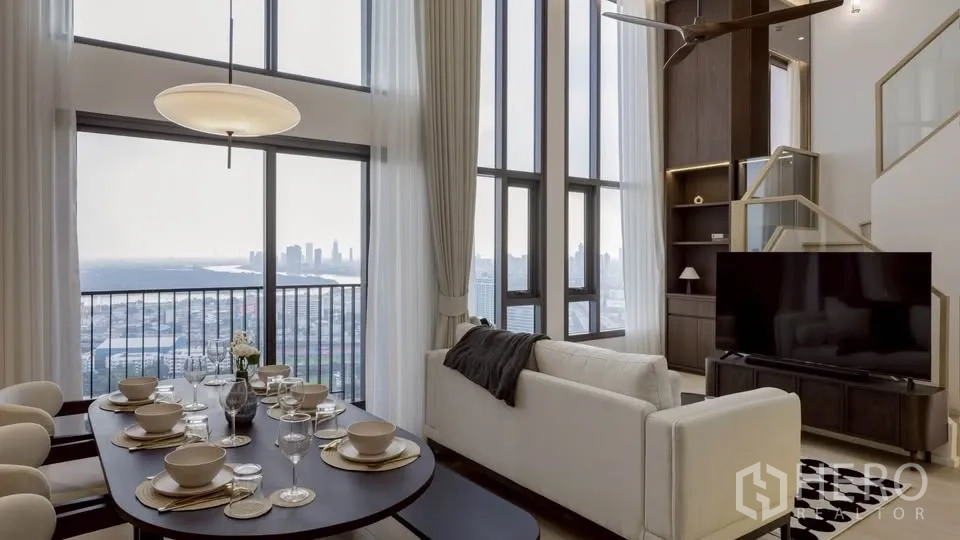คอนโด for rent in Khlong Toei, Bangkok - พื้นที่นั่งเล่นและรับประทานอาหารแบบเปิดโล่ง พร้อมหน้าต่างสูงจรดเพดานเห็นวิวเมืองและแม่น้ำ.