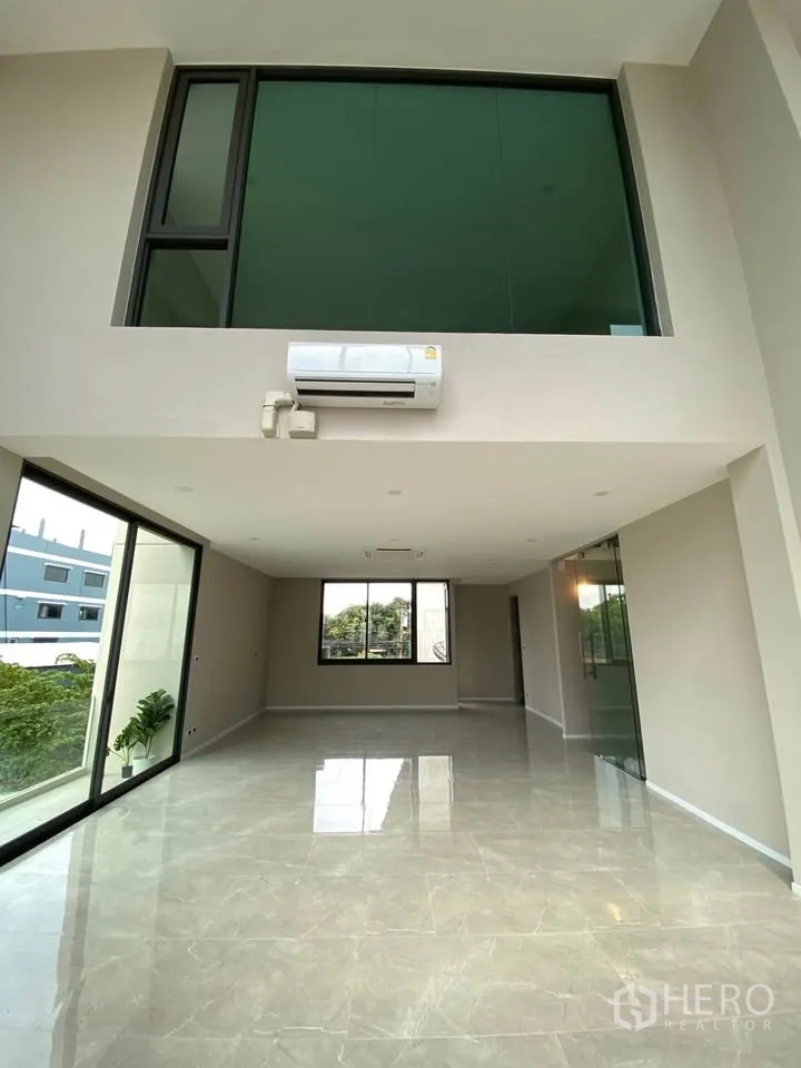 家庭办公室 for rent or sale in Suan Luang, Bangkok - 整面落地窗俯瞰住宅与树景。