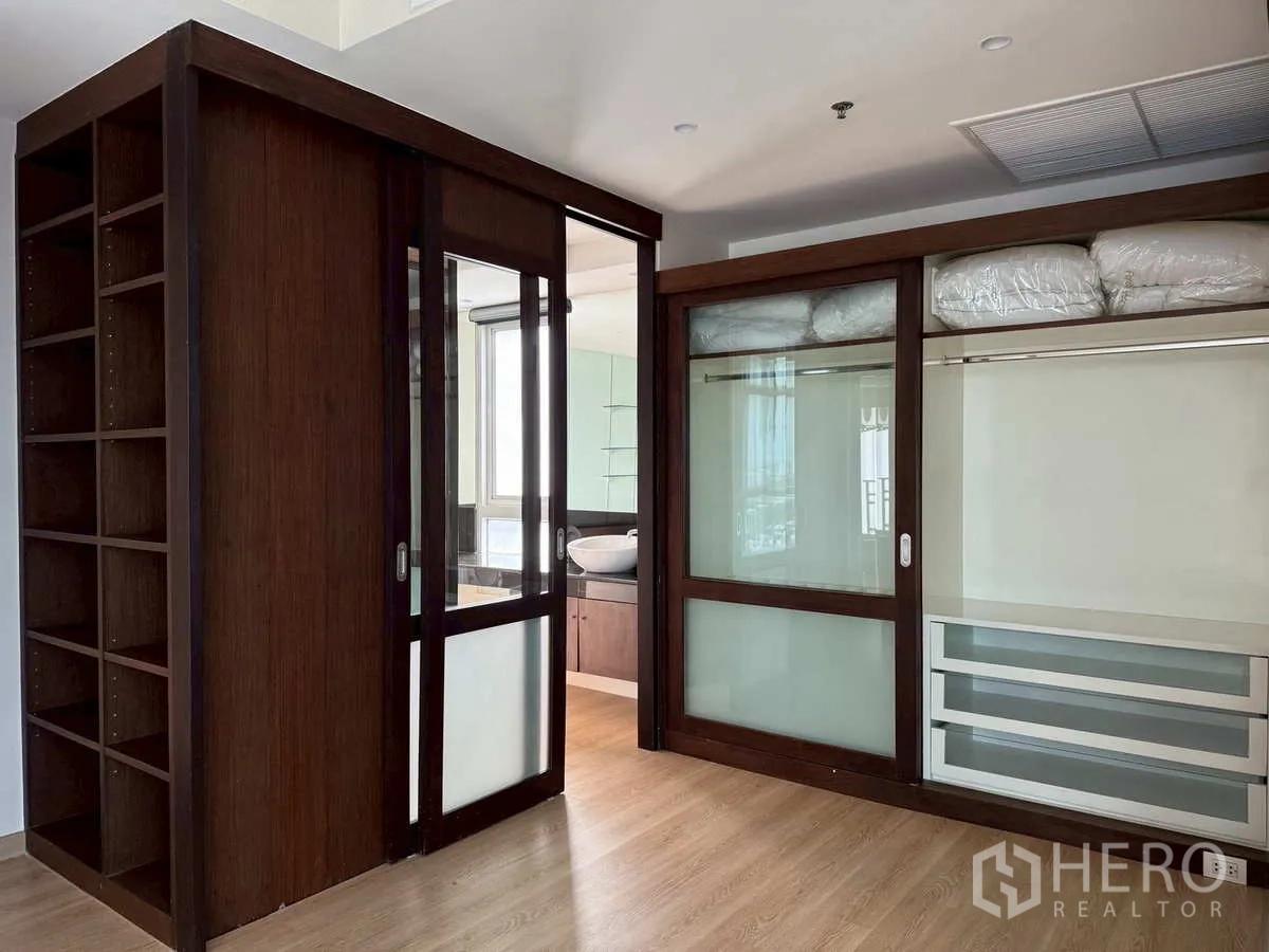 Condominium for rent or sale in Khlong Toei, Bangkok - Walk-in closet with sliding glass doors and built-in wardrobe system.