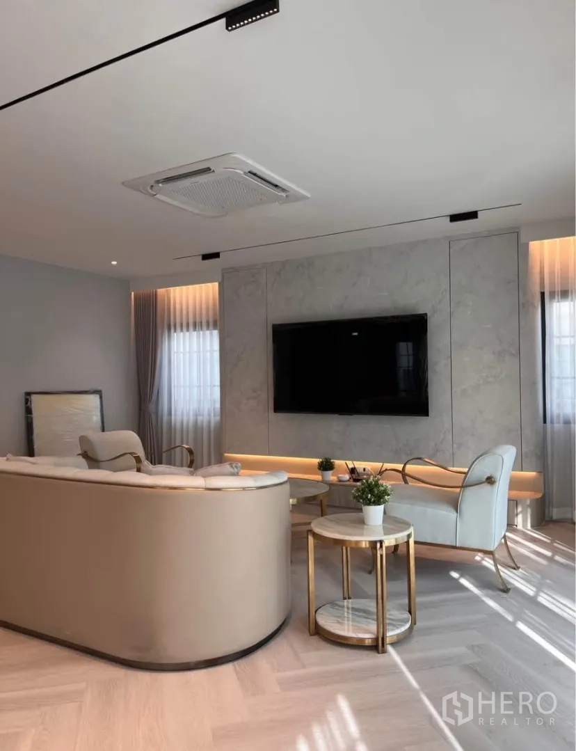 独栋房屋 for rent in Bang Phli, Samut Prakan - 客厅电视背景墙，弧形沙发，圆形边几与嵌入式照明。