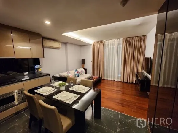 公寓 出租在Watthana, Bangkok - 餐区紧邻厨房，明亮客厅和大窗帘带来充足采光。