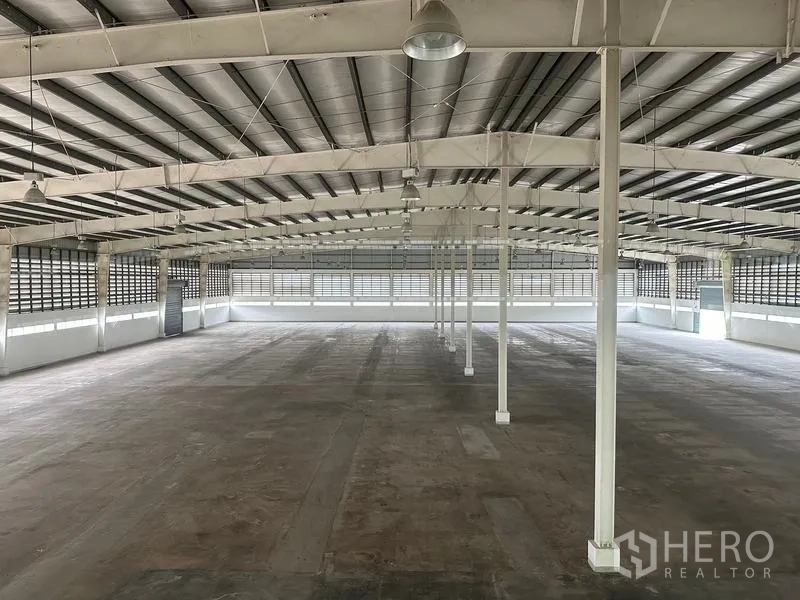 Factory for rent in Pathum Thani - Spacious factory floor with steel trusses, insulated roof, and concrete slab.
