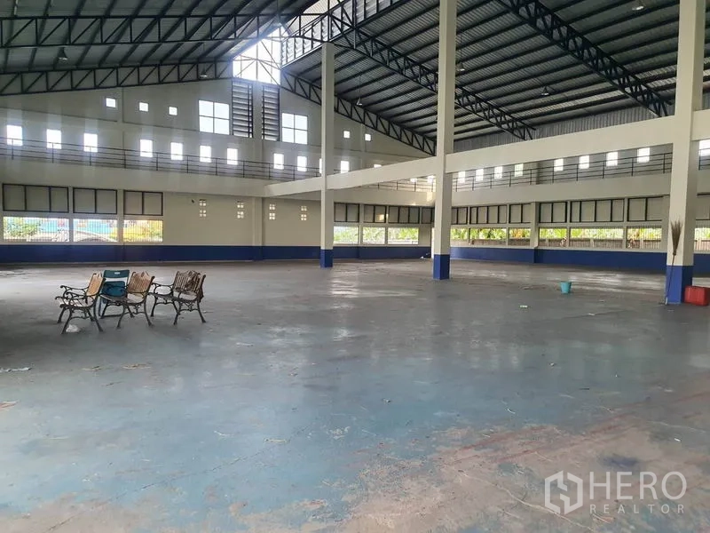 Factory for rent in Bang Bua Thong, Nonthaburi - Spacious high-ceiling production hall with steel trusses and an open floor area.