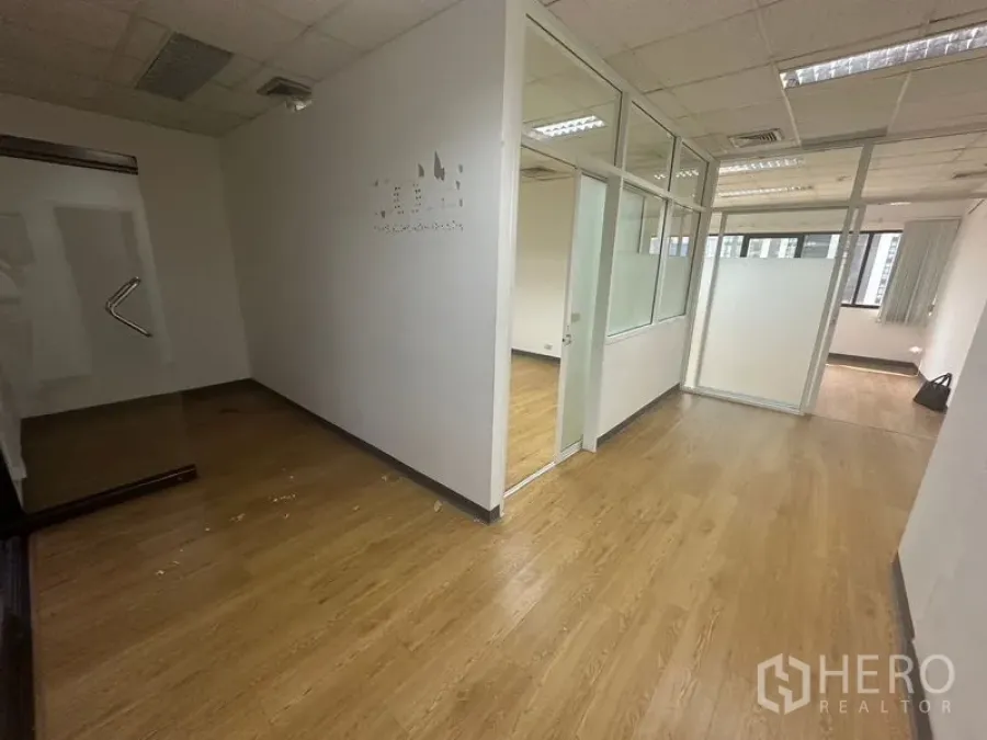 办公空间 出租在Watthana, Bangkok - 入口或接待区，玻璃隔间与木纹地板，整洁明亮。