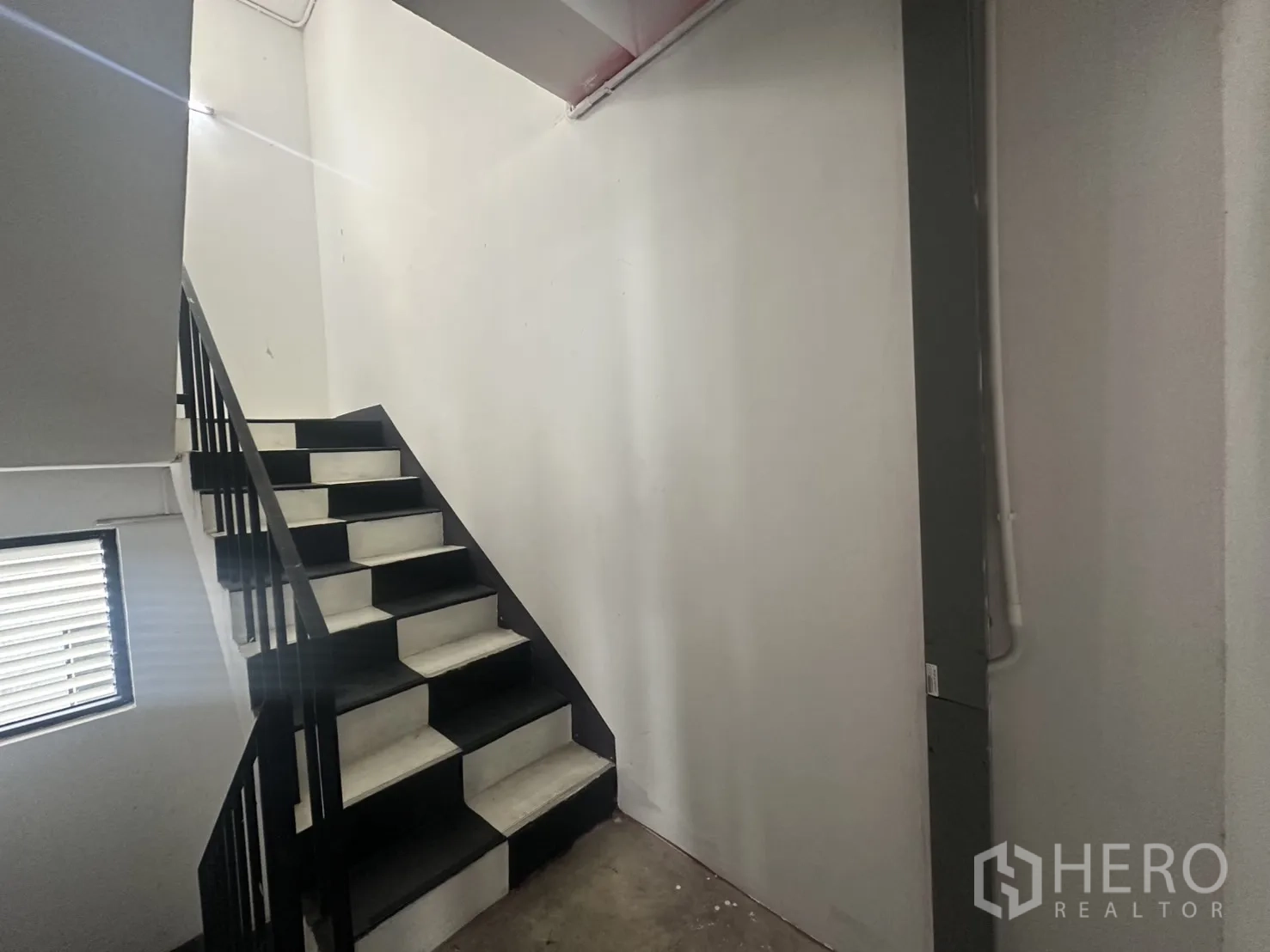 带办公室的家 出租在Pathum Wan, Bangkok - 室内楼梯，黑色扶手连接多层空间。