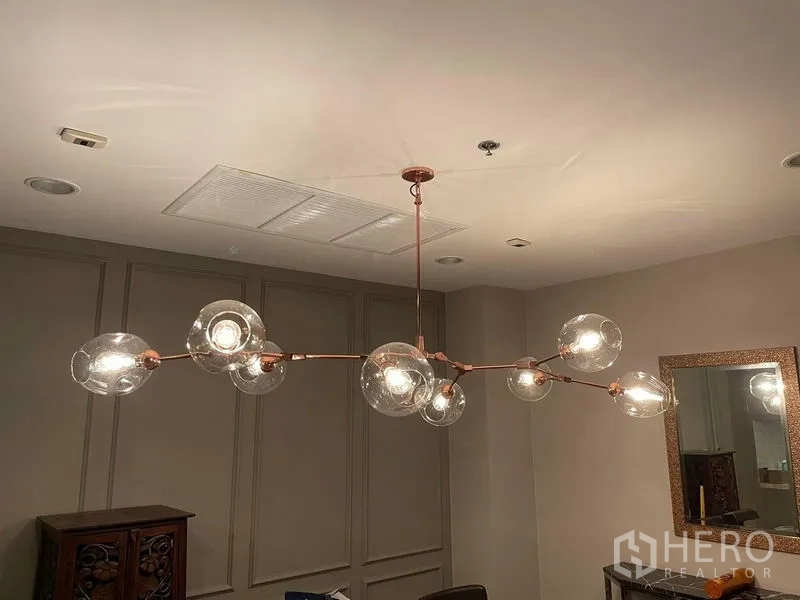 Condominium for sale in Sathon, Bangkok - Close-up of contemporary glass-bubble chandelier on a copper frame in the dining area.