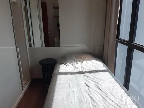 Condominium for rent in Khlong Toei, Bangkok - Compact bedroom with single bed, floor-to-ceiling window and built-in wardrobe.