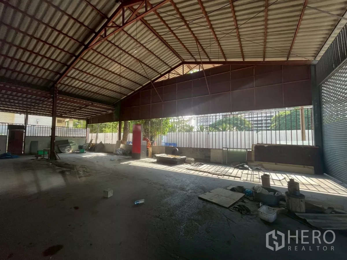 Warehouse for rent or sale in Yan Nawa, Bangkok - Open warehouse interior with steel truss roof and wide loading opening allowing natural light.