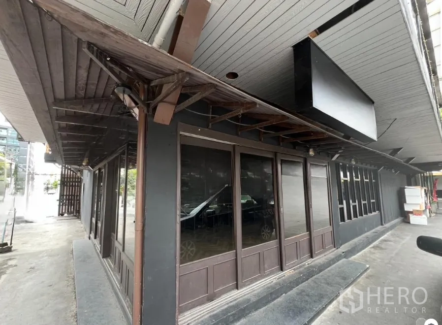 Retail Space for rent in Watthana, Bangkok - Ground-floor corner retail facade with dark wood awning and full-height glass windows in the Thonglor area.