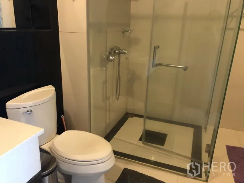 公寓 出租在Pathum Wan, Bangkok - 现代浴室，玻璃淋浴房与白色马桶。