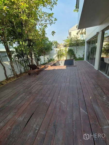 Detached House for rent in Bang Kruai, Nonthaburi - Large wooden terrace along the house with greenery and a small pool.
