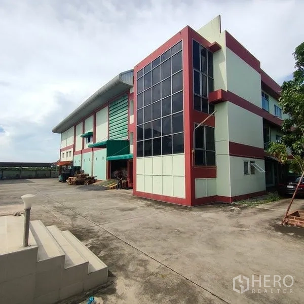 Factory for rent in Mueang Samut Sakhon, Samut Sakhon - Modern factory exterior with glass-front office block and wide concrete yard.