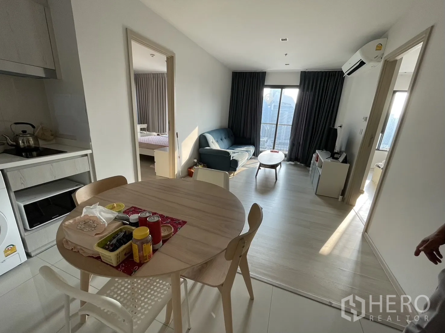 公寓 for rent in Pathum Wan, Bangkok - 开放式餐客厅，圆桌、沙发，尽头为可通阳台的大窗。