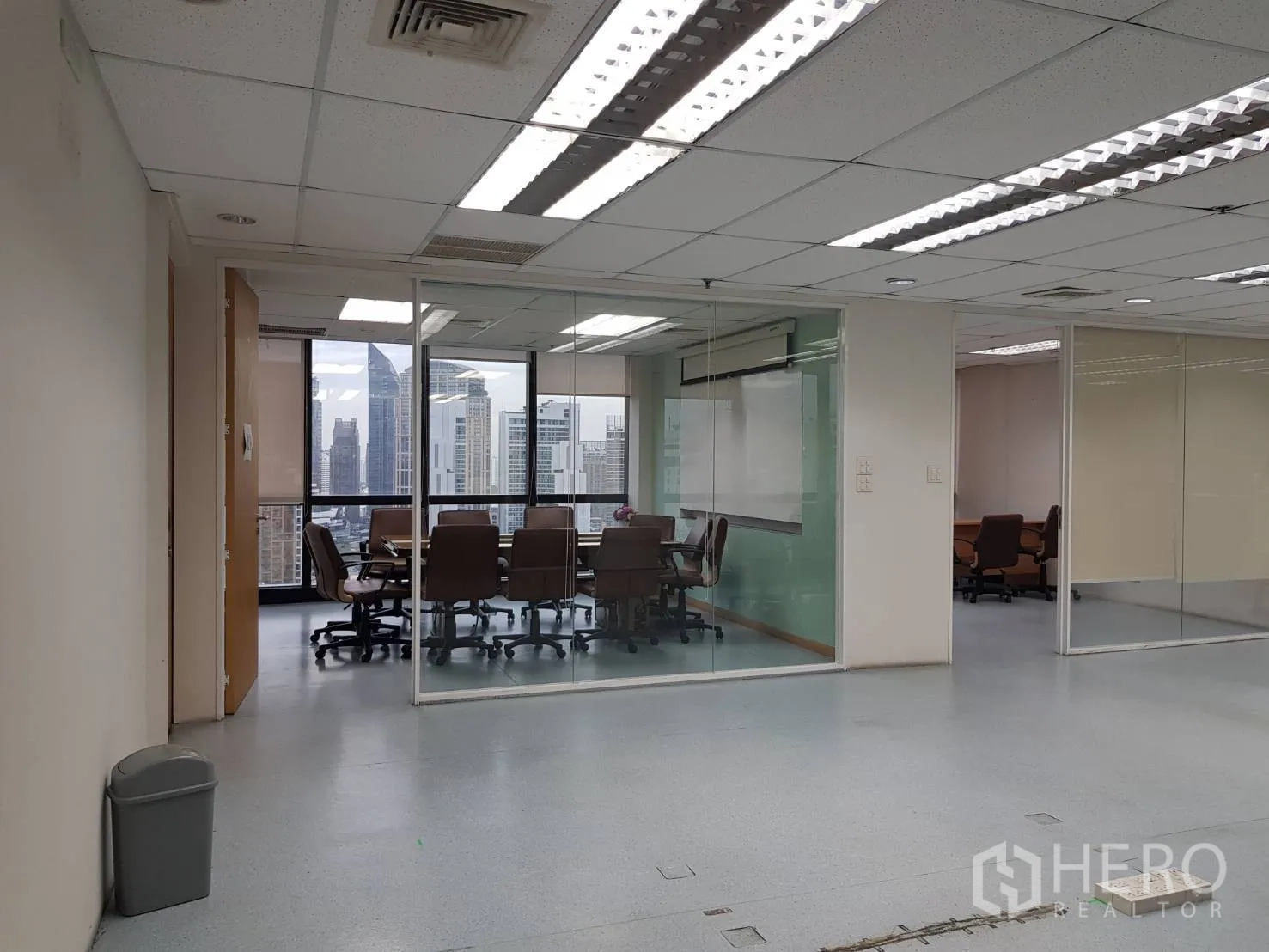 办公空间 出租在Bang Na, Bangkok - 透明玻璃墙会议室，俯瞰城市天际线的空堤区高层办公空间。
