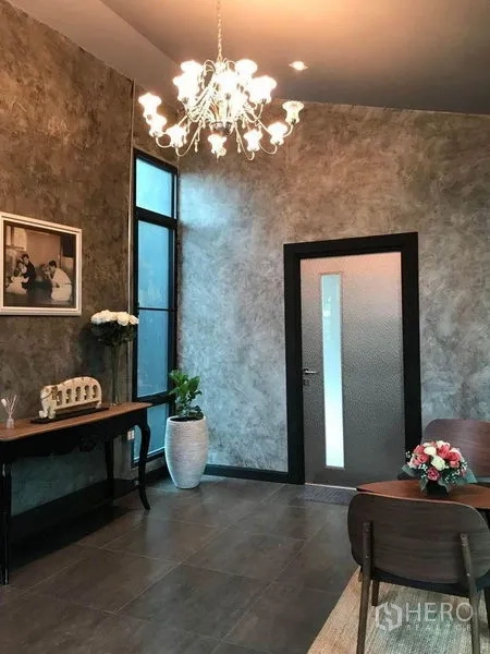 办公空间 出租在Bang Kapi, Bangkok - 接待区，水晶吊灯、质感墙面与深色门。