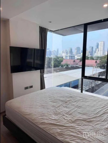 公寓 出租在Khlong Toei, Bangkok - 转角卧室带城市天际线景观与壁挂电视。