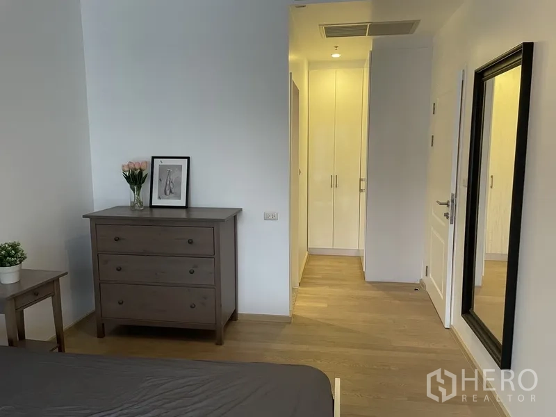 Condominium for rent in Bangkok - Bedroom corner with dresser, full-length mirror and built-in wardrobe.