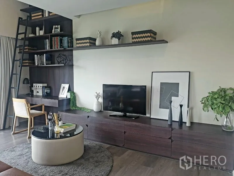 Home Office for rent - Living area with built‑in media wall, TV and laddered bookshelves.