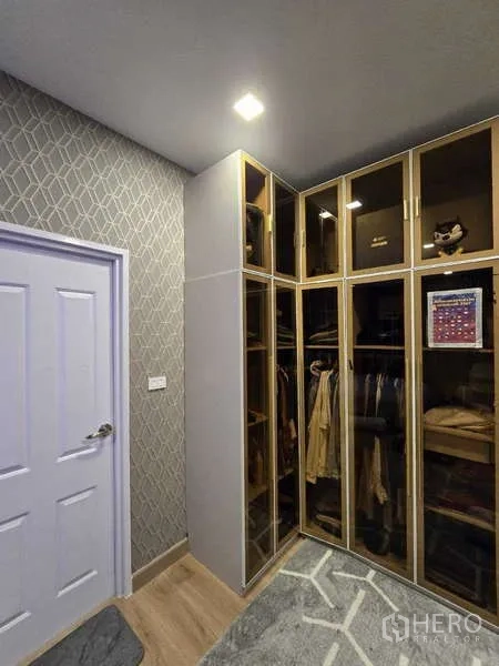Detached House for rent in Thanyaburi, Pathum Thani - Walk-in closet room fitted with floor-to-ceiling glass wardrobes and geometric wallpaper.