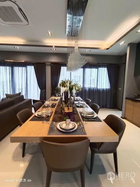 独立式住宅 出售在Wang Thonglang, Bangkok - 优雅餐厅，长木桌可坐八人，水晶吊灯营造氛围。