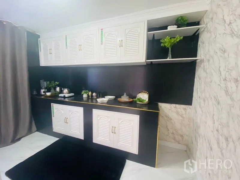 Condominium for rent or sale in Watthana, Bangkok - Compact pantry kitchen with white louvered cabinets and black backsplash.
