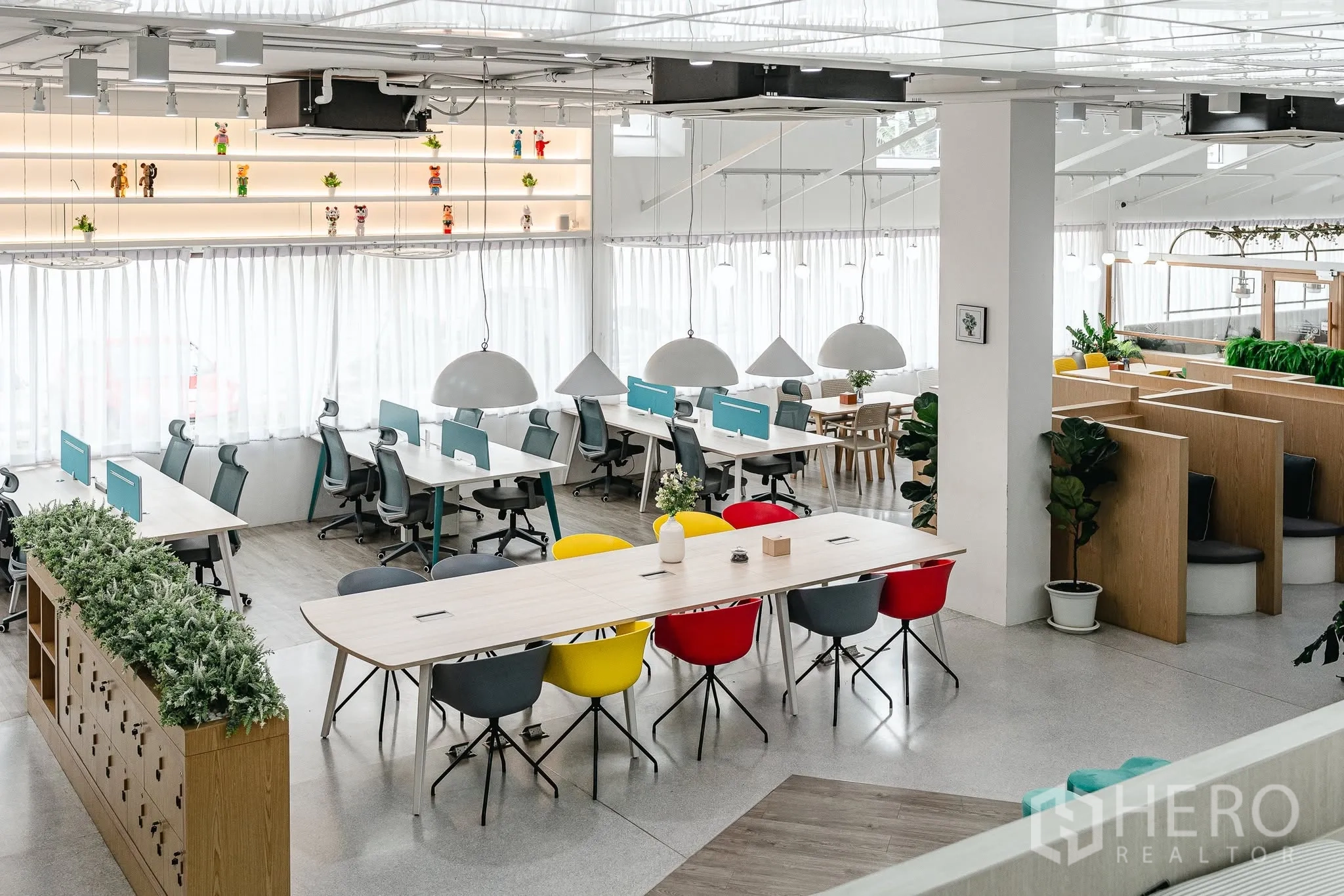 Office Space for rent in Bang Kapi, Bangkok - Open-plan coworking floor with long tables, desk clusters, and pendant lamps by wide windows.